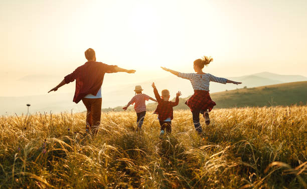 Happy family: mother, father, children son and daughter on nature on sunset Se libérer de ces chaînes